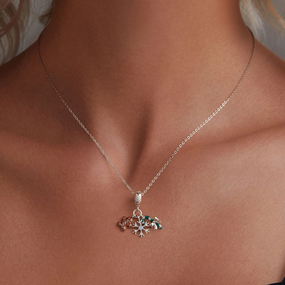 Sterling silver Christmas charm with gingerbread man, candy cane, bow, snowflake, and sparkling crystal details.