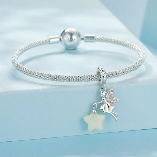 Sterling silver fairy charm holding glowing star with crystal wing details.