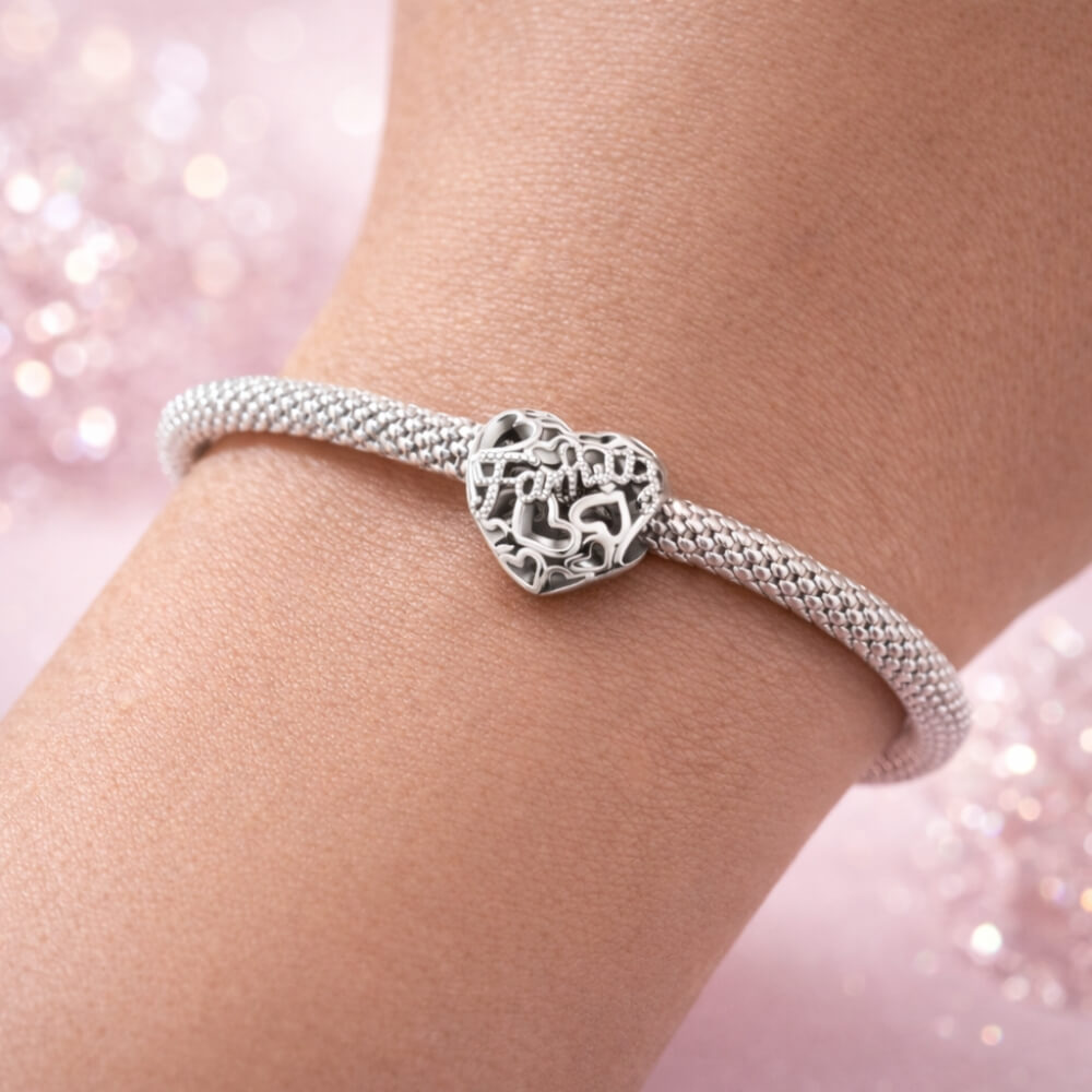 Sterling silver heart charm with Family text and cutout hearts.