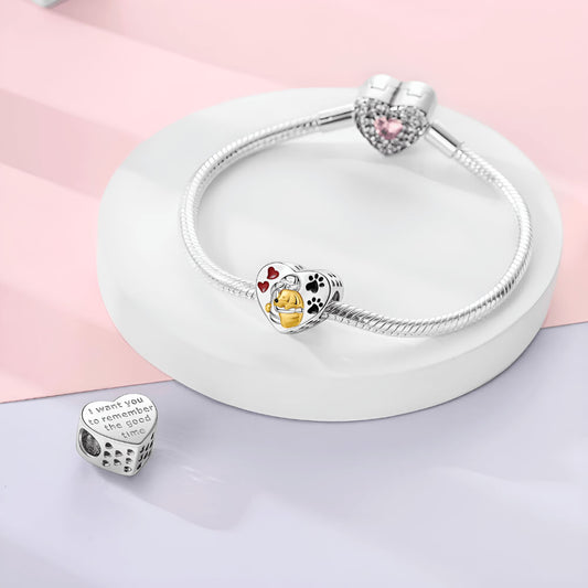 Sterling silver heart charm with gold-tone dog hugging a person, red hearts, and black paw prints
