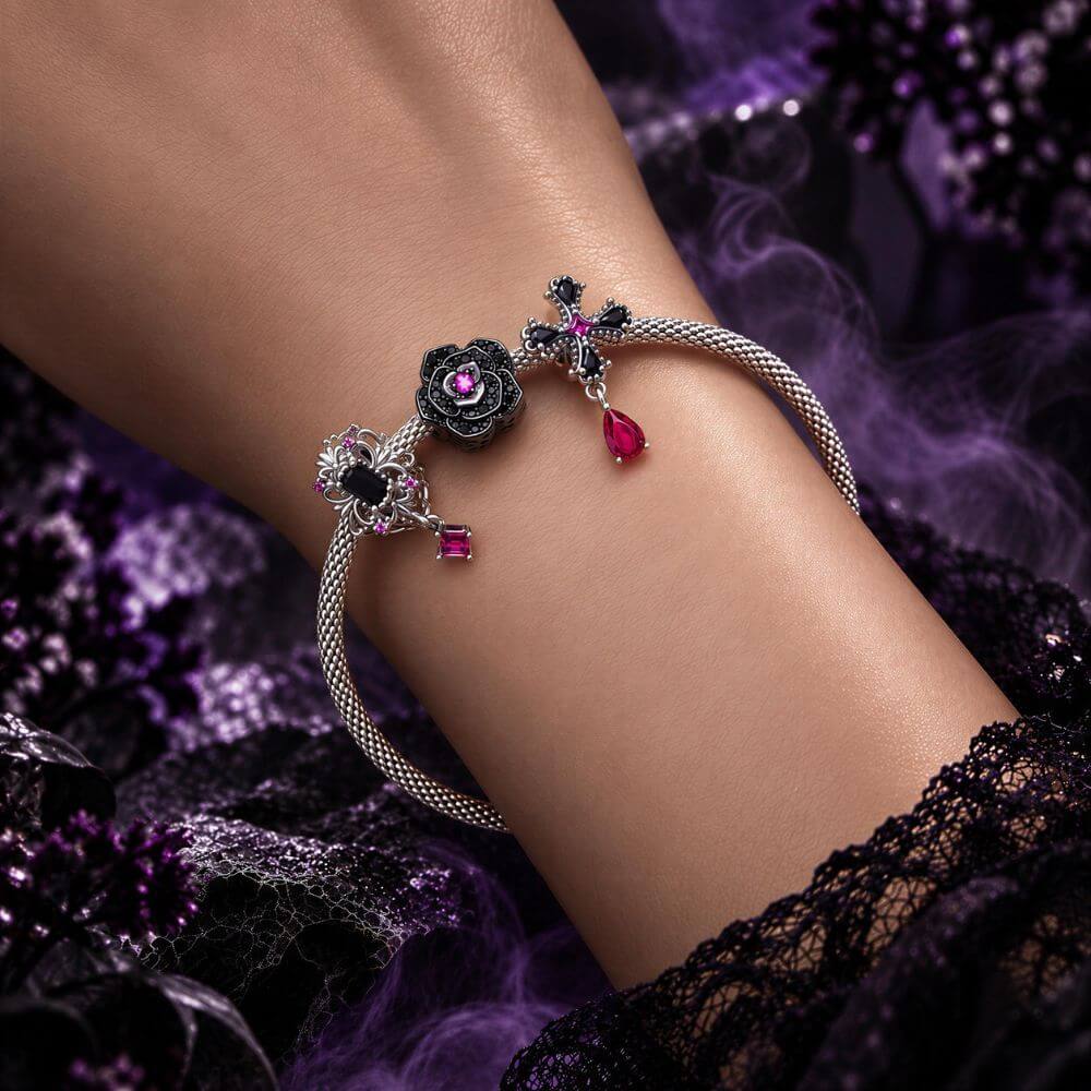 Sterling silver gothic cross charm with black crystals, pink center stone, and dangling magenta crystal drop.