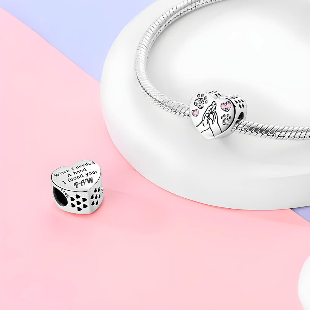Sterling silver heart charm with engraved hand and paw design and pink crystal accents
