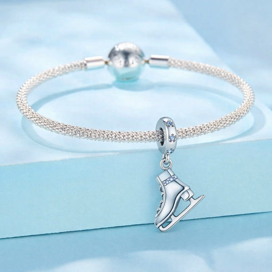 Sterling silver ice skate charm with blue crystal details and winter sparkle.
