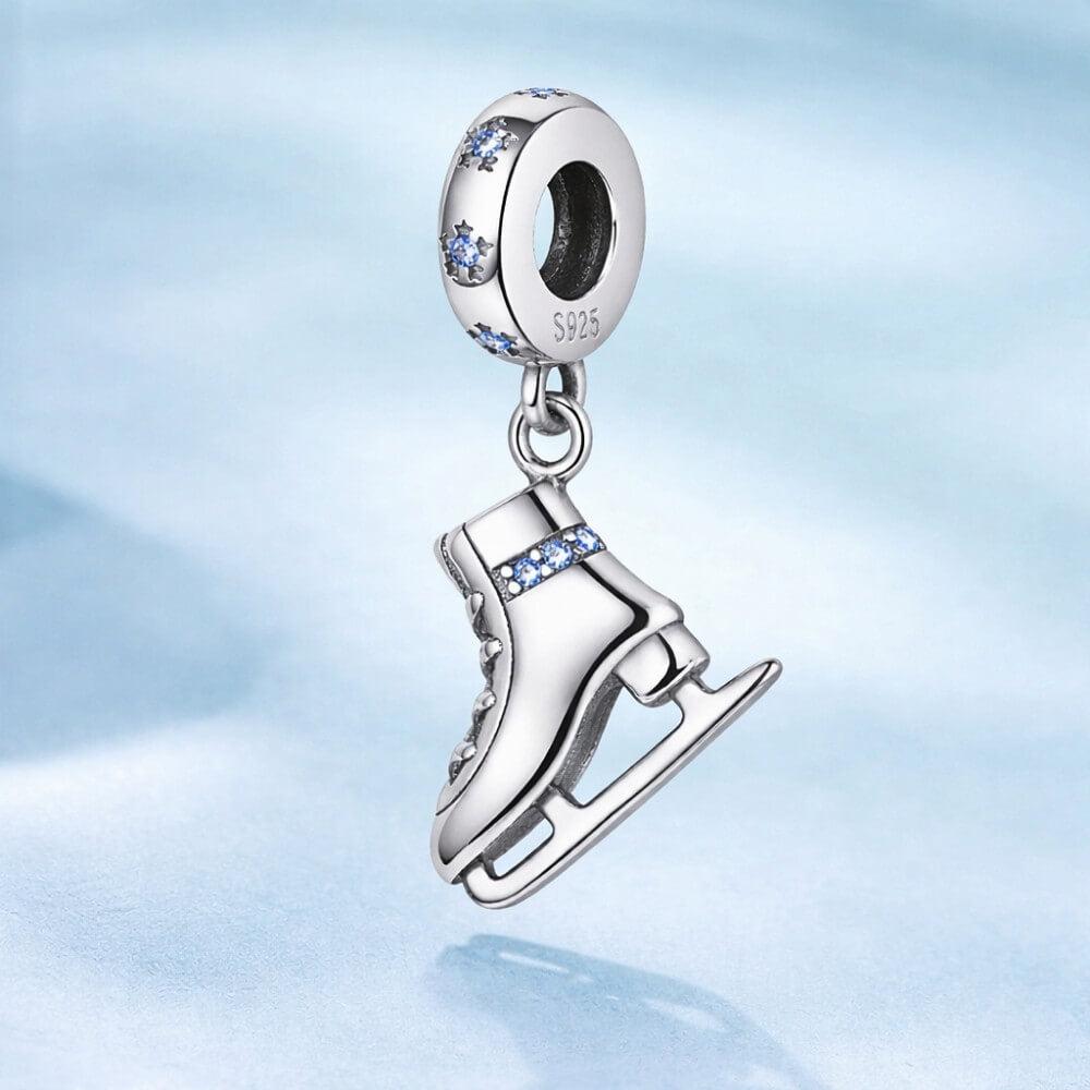 Sterling silver ice skate charm with blue crystal details and winter sparkle.