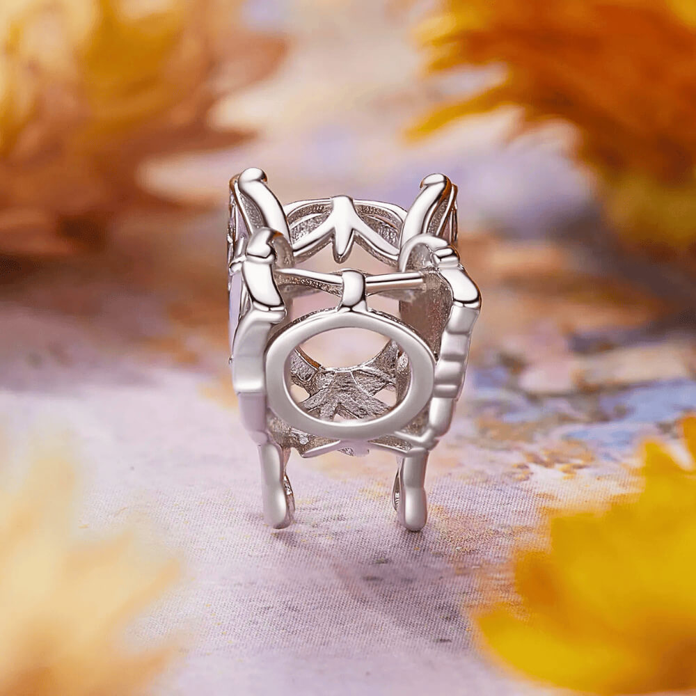 Sterling silver butterfly charm with lavender enamel wings, leaf-shaped filigree details, and an opal-like central gemstone