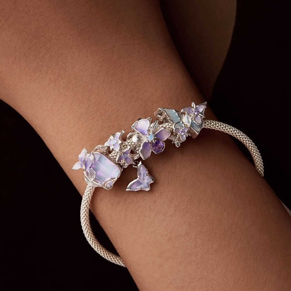 Sterling silver crystal charm with lavender flower and iridescent stone.