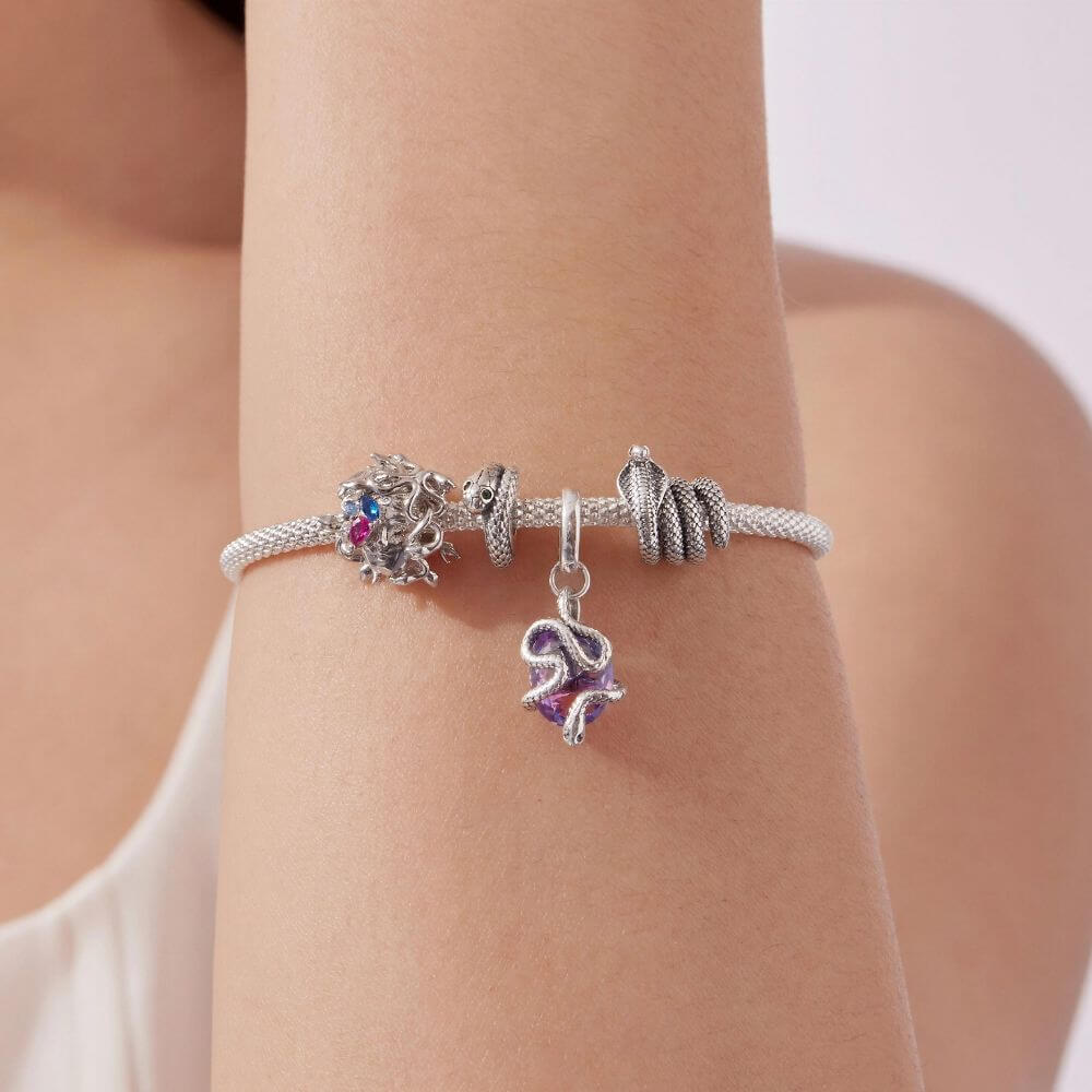 Sterling silver Medusa charm with sculpted snake hair and vivid pink, blue, and clear crystal details.