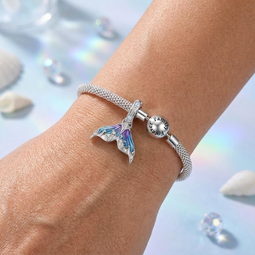 Sterling silver mermaid tail charm with blue purple enamel and crystal details.