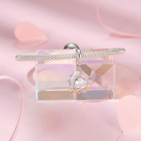 Sterling silver mom angel charm with heart crystal and gold lettering.