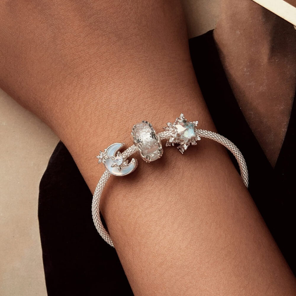 Sterling silver moon charm with iridescent enamel and floral crystal details.