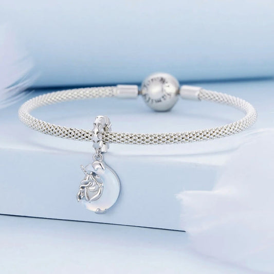 Sterling silver unicorn charm on moon with opalescent glow.