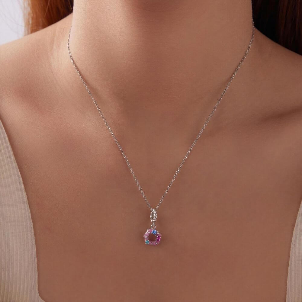 Sterling silver donut charm with pink frosting, colorful crystal sprinkles, and a twisted silver bail.