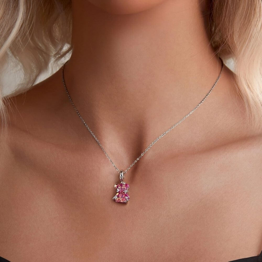 Sterling silver pink teddy bear charm with iridescent finish, sparkling stars, and clear crystal accents.