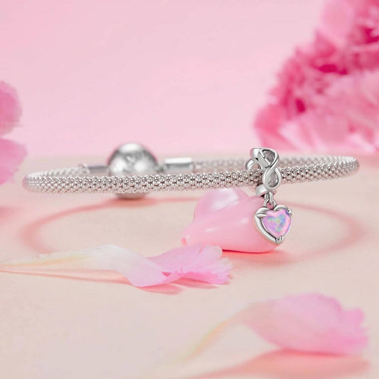 Sterling silver heart charm with pink opal center, infinity loop, and sparkling clear crystal details.