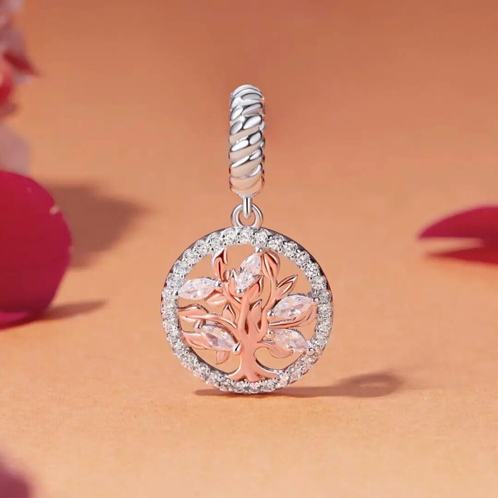 Sterling silver tree charm with rose gold branches, clear gemstones, and circular frame.