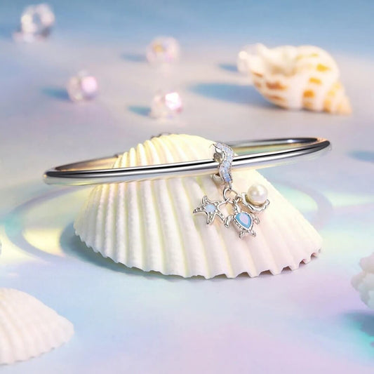 Sterling silver sea charm with turtle, pearl, and starfish details.