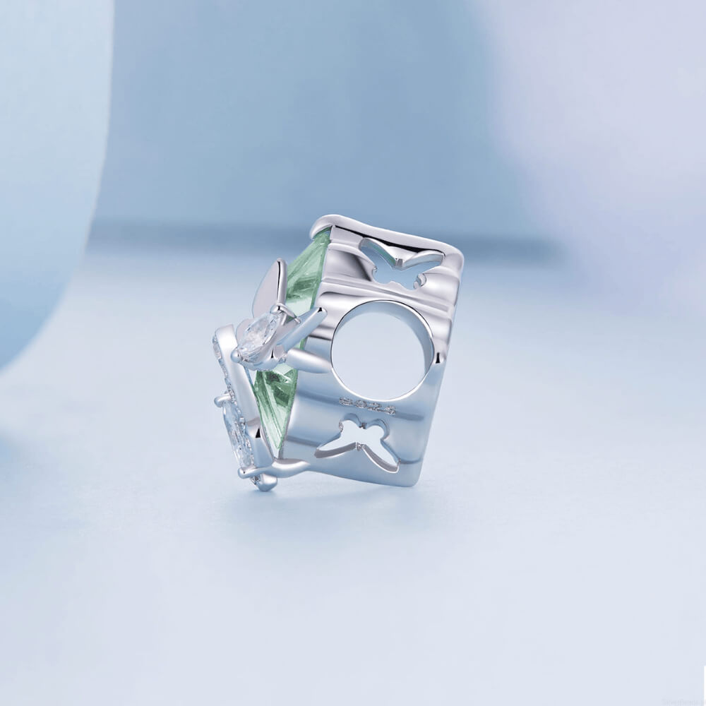Sterling silver charm with a large pale green faceted stone and two crystal-studded silver butterflies on the front