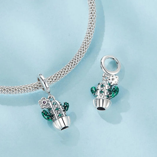 Sterling silver cactus charm with green enamel arms, green gemstones, and a small flower pendant with a pink crystal
