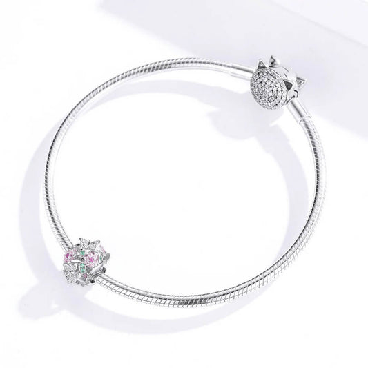 Sterling silver openwork charm with pink crystal flowers, green crystal leaves, and silver butterflies with clear stones