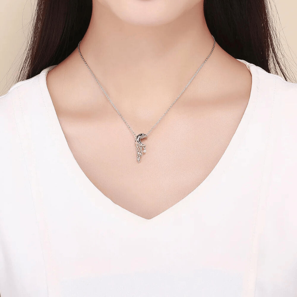 Sterling silver crescent moon charm with clear, dark blue, and light blue stones, featuring three dangling star and circle crystal accents