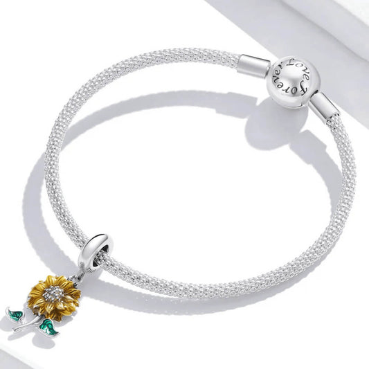 Sterling silver sunflower charm with yellow enamel petals, a crystal-studded center, and two green enamel leaves