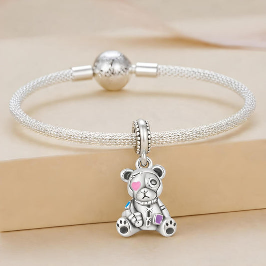 Sterling silver teddy bear charm with stitched details and enamel accents.