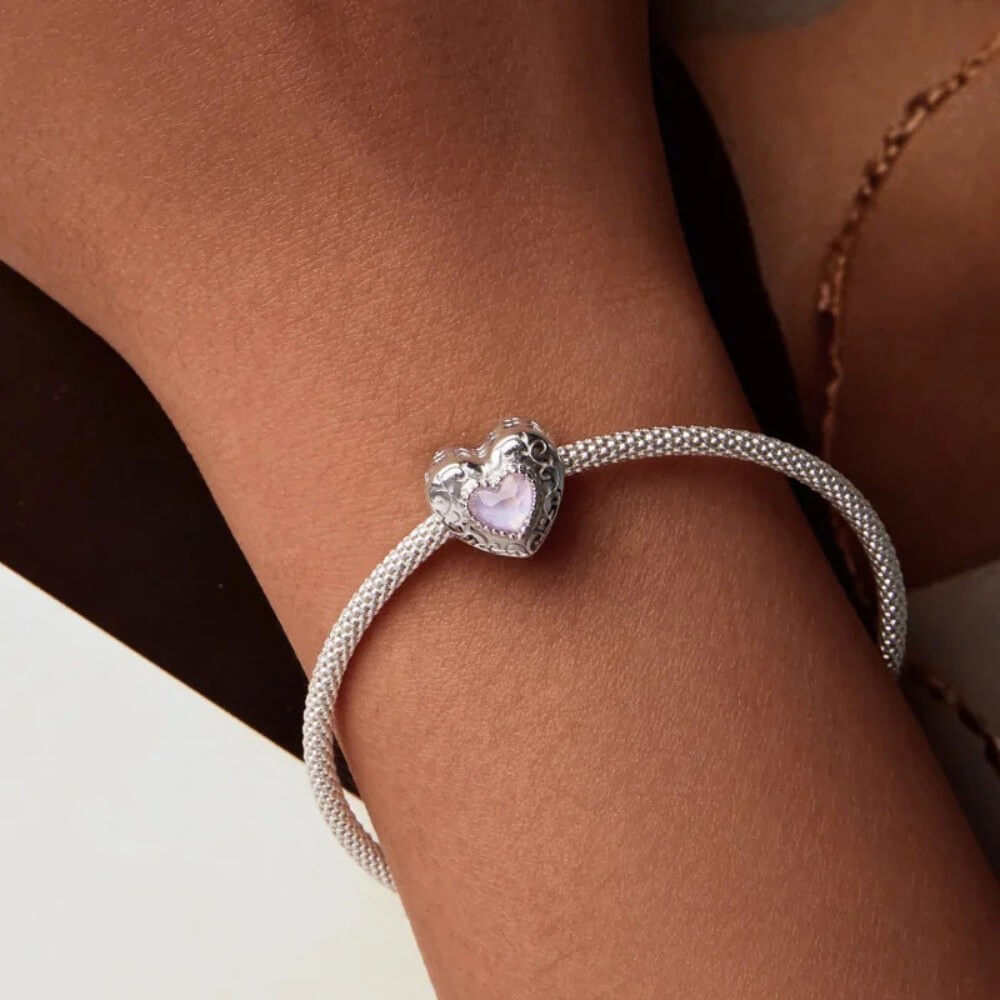 Sterling silver swan heart charm with pink crystal and pavé border.