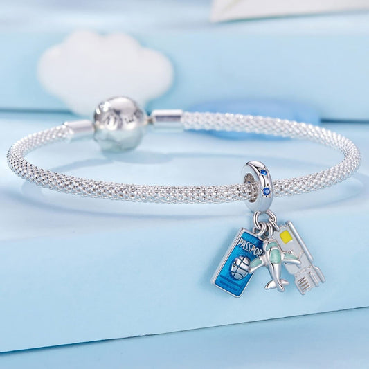 Silver bracelet with travel-themed charms on a light blue background