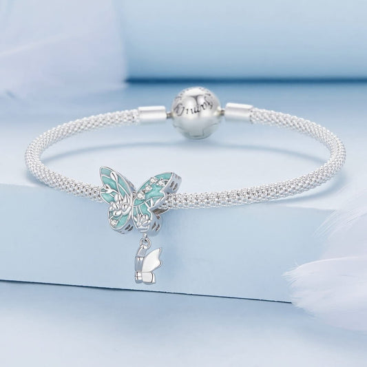 Silver bracelet with butterfly charm on a light blue background