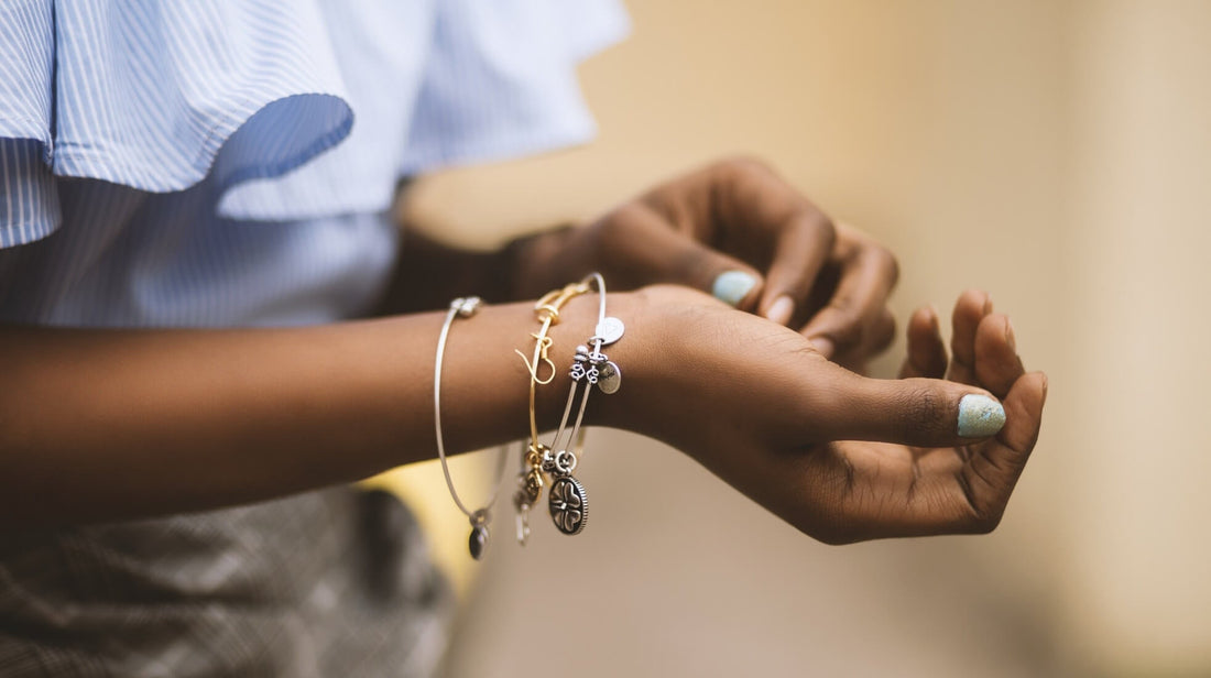 Woman wearing charm bracelets on her wrist, symbolizing memories and emotional moments