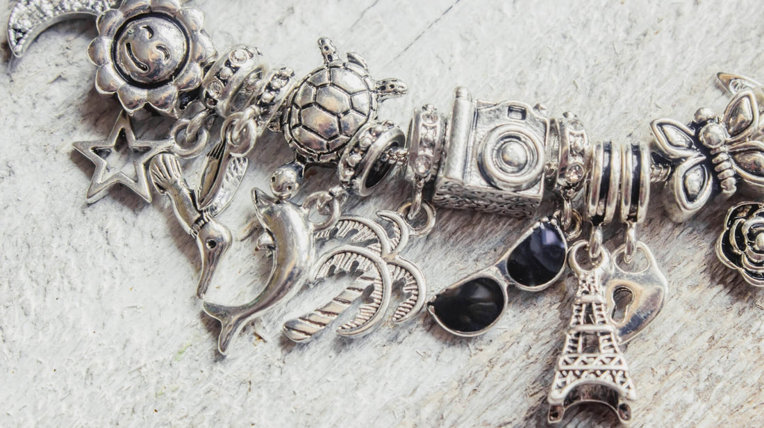 Close up of a silver charm bracelet with multiple detailed charms
