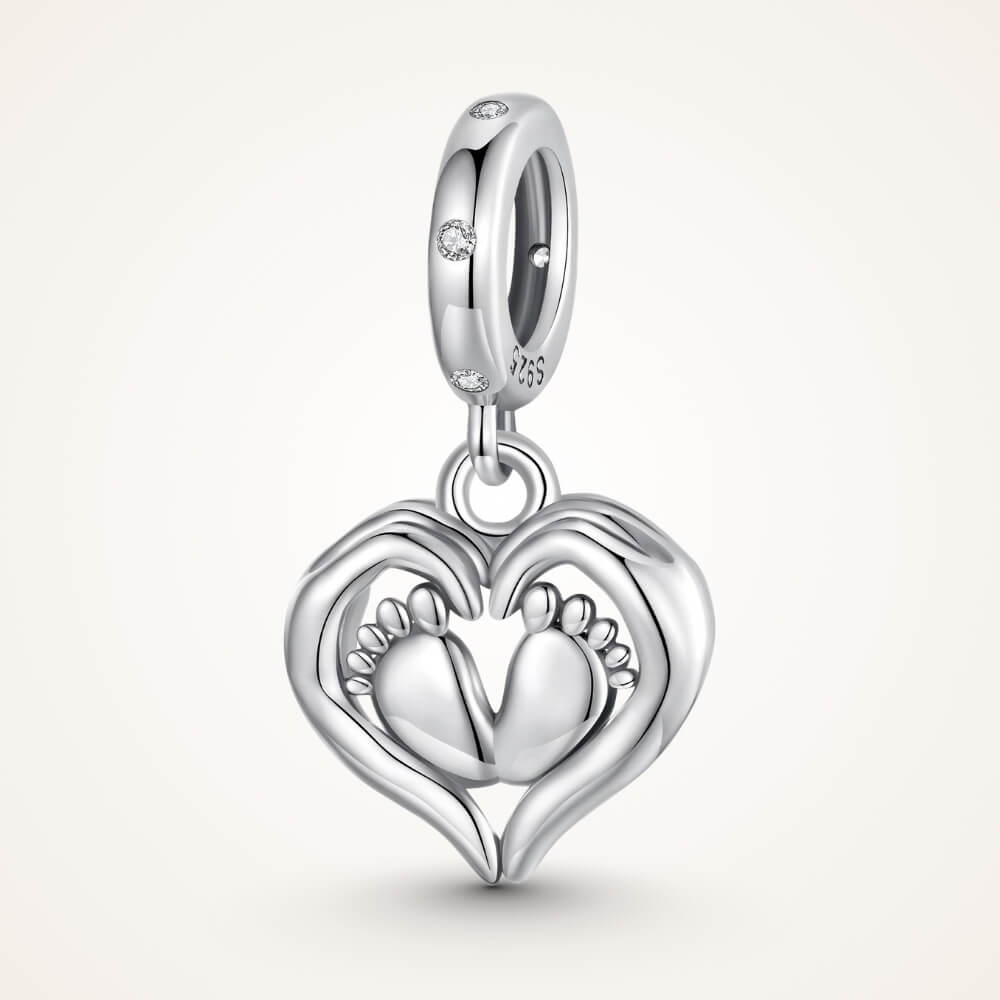 Sterling silver baby feet charm framed by a heart with sparkling crystal accents and delicate polished details - ORÉYA