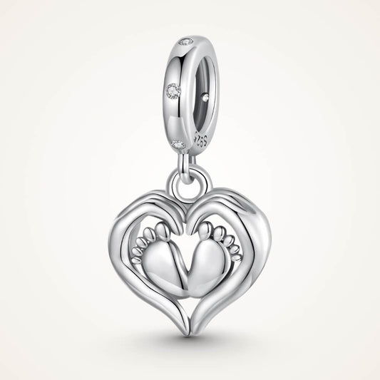 Sterling silver baby feet charm framed by a heart with sparkling crystal accents and delicate polished details - ORÉYA