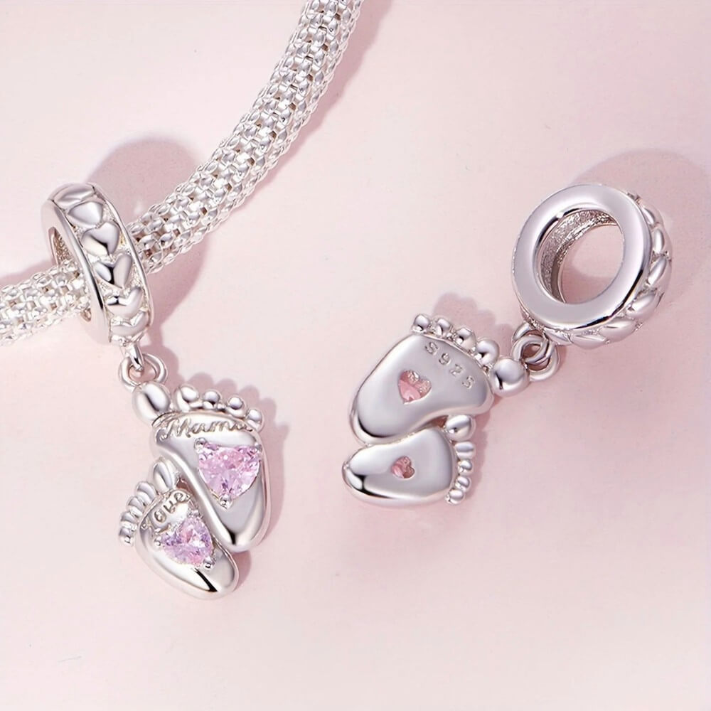 Sterling silver baby feet charm with pink heart crystals and mom engraving.