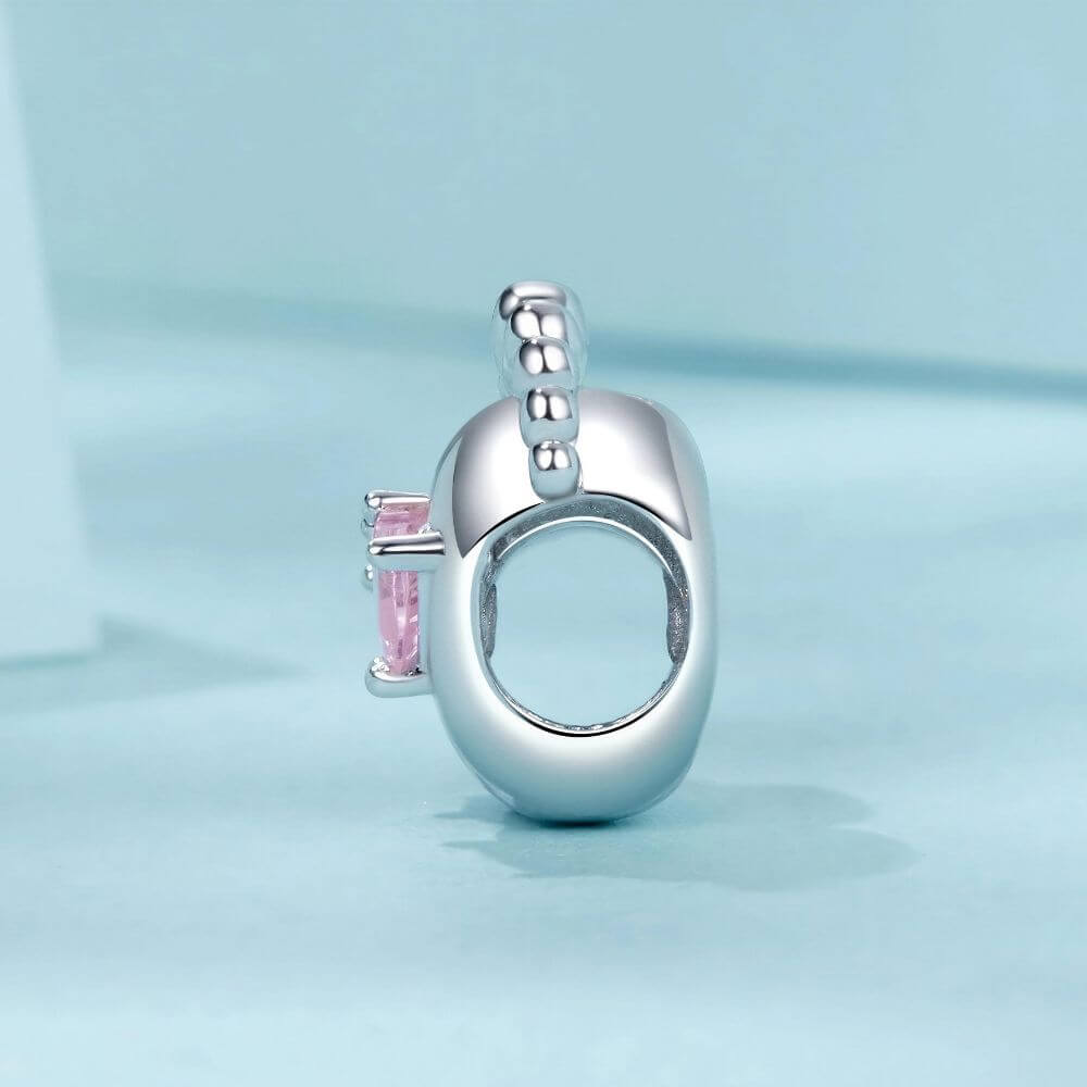 Sterling silver baby feet charm with two pink heart crystals and polished newborn footprint details.