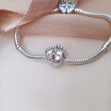 Sterling silver baby feet charm with two pink heart crystals and polished newborn footprint details.