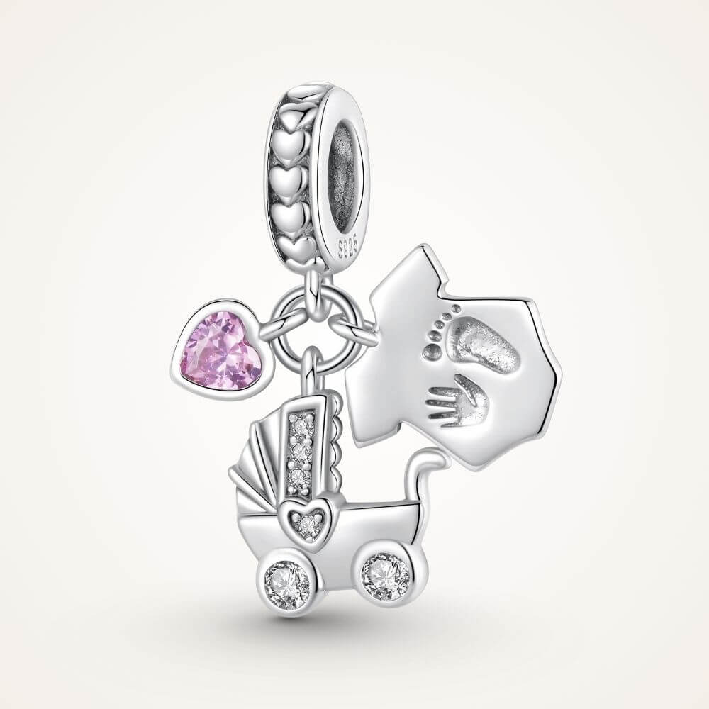 Sterling silver baby charm with stroller, pink heart crystal, house tag, and tiny hand and footprint details - ORÉYA
