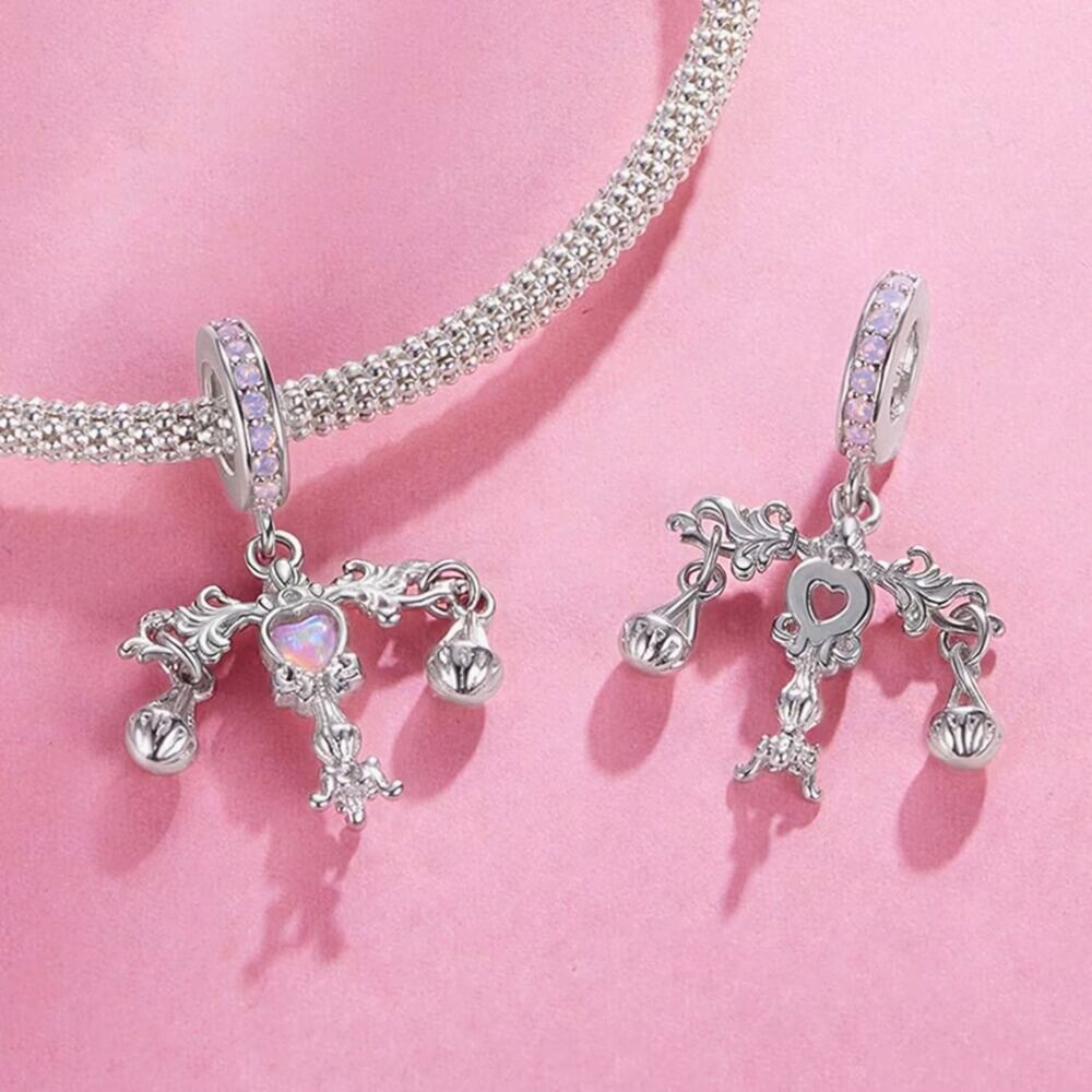 Sterling silver balance charm with opal heart center and hanging scales.