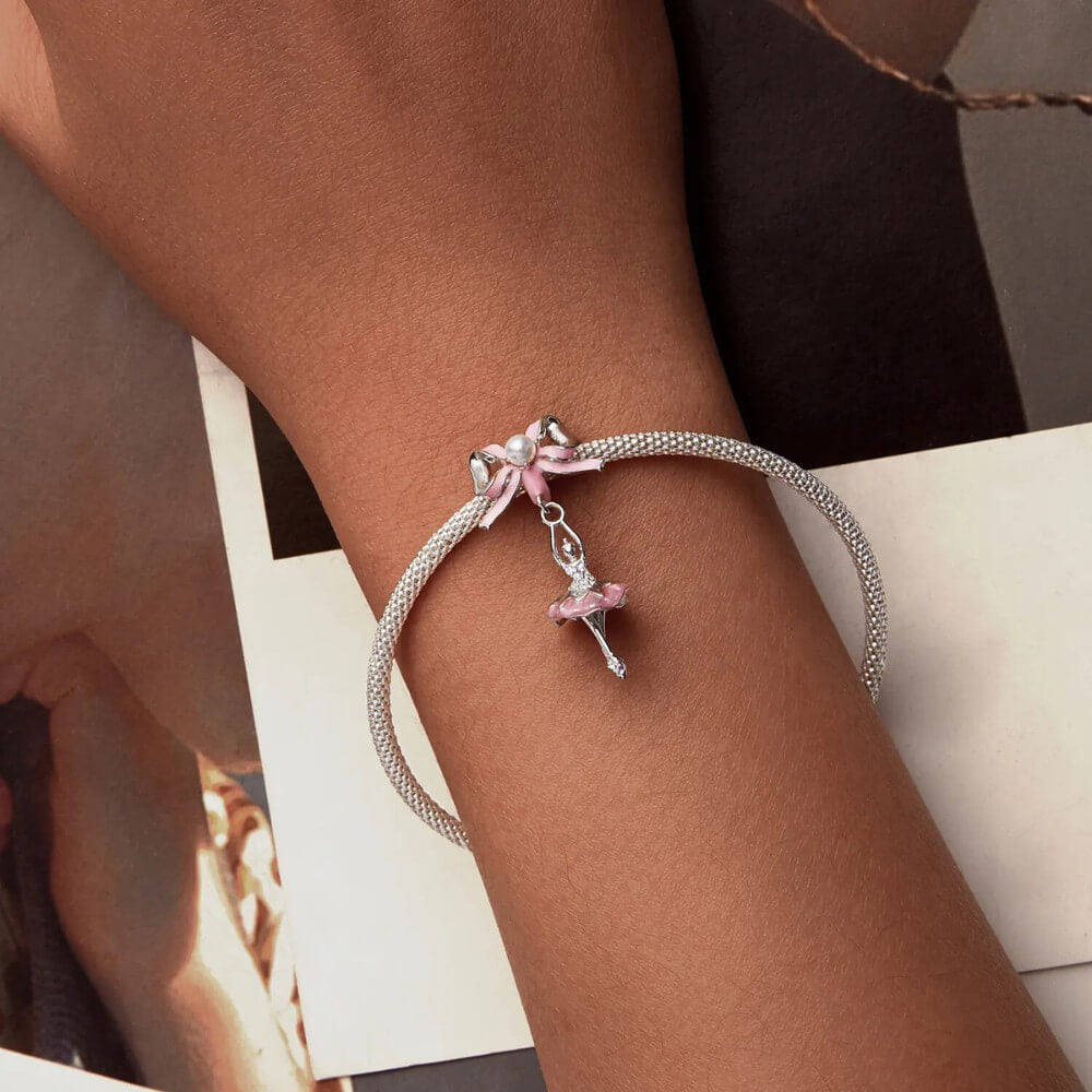 Sterling silver ballerina charm with pink enamel bow and crystal accents.