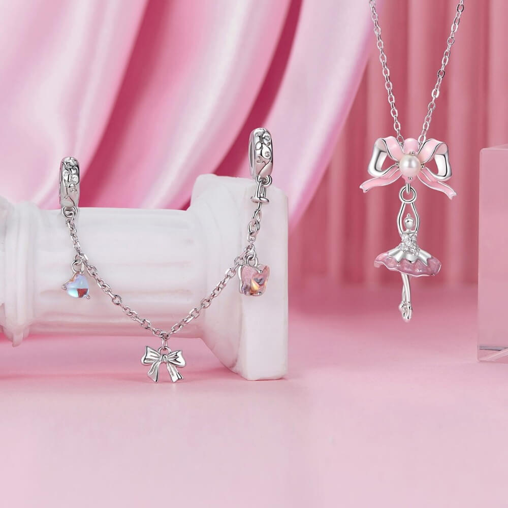 Sterling silver ballerina charm with pink enamel bow and crystal accents.