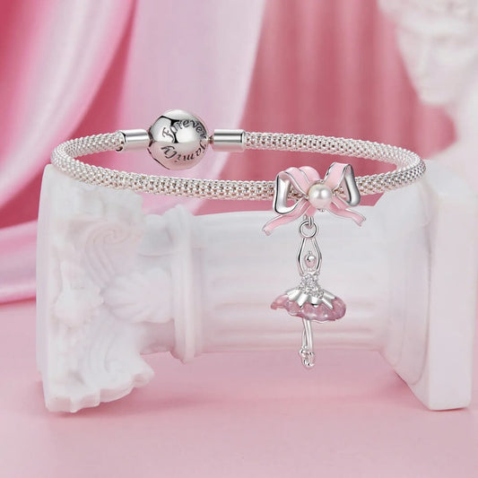 Sterling silver ballerina charm with pink enamel bow and crystal accents.
