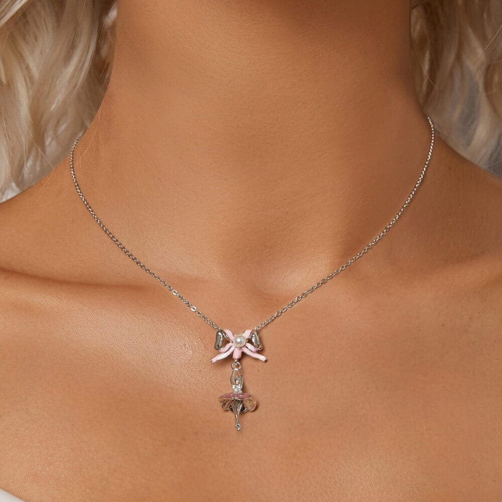 Sterling silver ballerina charm with pink enamel bow and crystal accents.