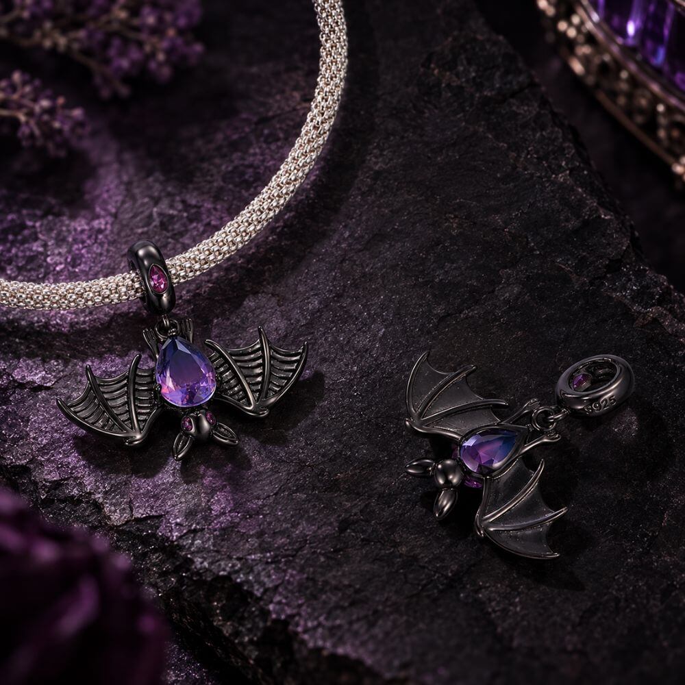Black bat charm with purple blue crystal body, wide skeletal wings, and dark gothic Halloween details.