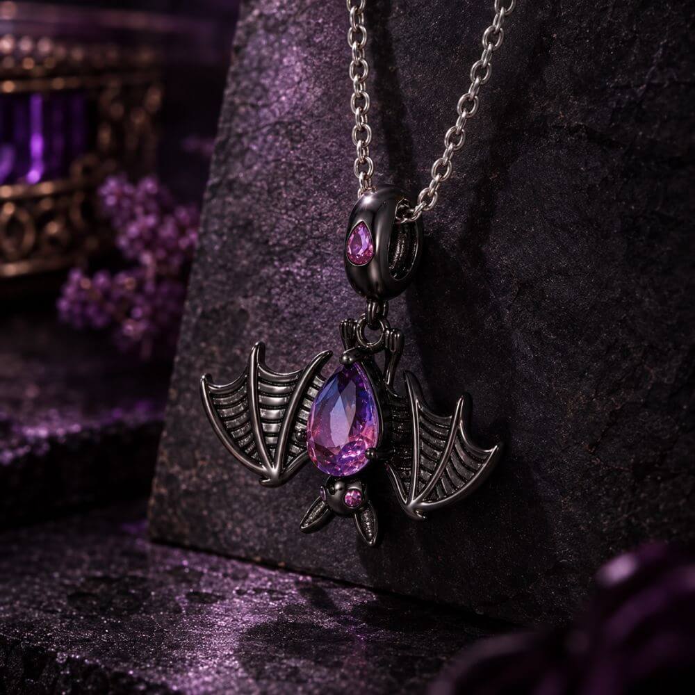 Black bat charm with purple blue crystal body, wide skeletal wings, and dark gothic Halloween details.