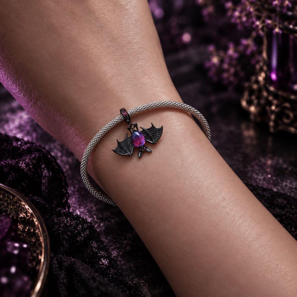 Black bat charm with purple blue crystal body, wide skeletal wings, and dark gothic Halloween details.