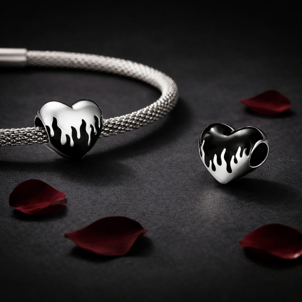 Sterling silver heart charm with black enamel flame design.