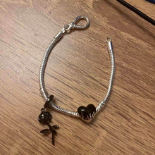 Sterling silver heart charm with black enamel flame design.
