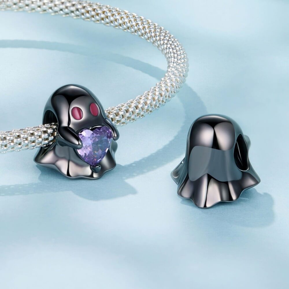 Black ghost charm holding purple heart crystal in sterling silver style.