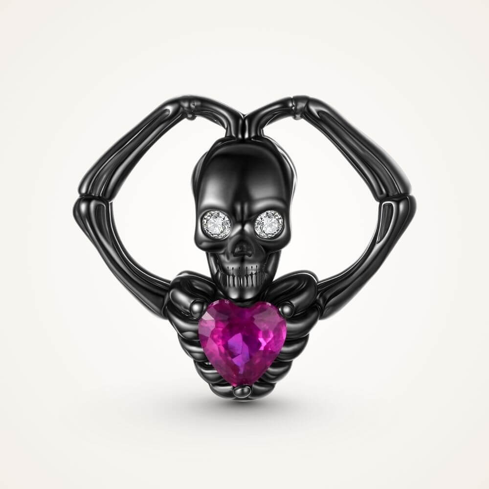 Black skeleton heart charm with crystal eyes, vivid pink heart stone, and gothic skeletal arm details - ORÉYA
