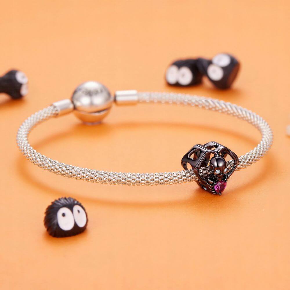Black skeleton heart charm with crystal eyes, vivid pink heart stone, and gothic skeletal arm details.